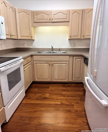 a kitchen with granite countertop a sink a stove and cabinets