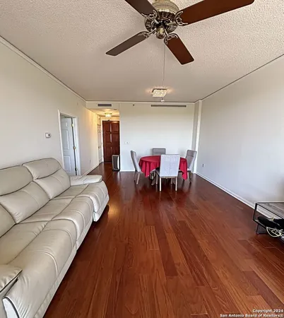 a living room with furniture and a wooden floor
