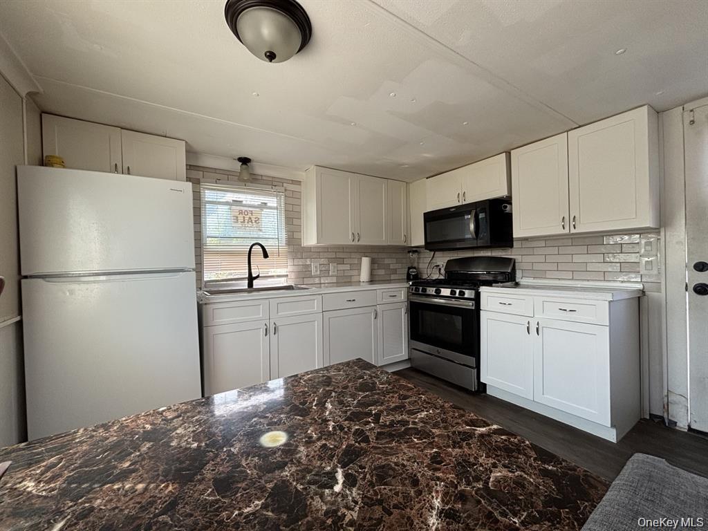 150 Main Street, Unit 57 Islip, NY 11751 - Photo 2 of 5 a kitchen with a refrigerator stove and white cabinets