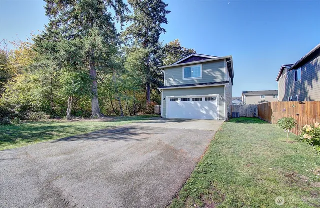 a front view of a house with a garden and trees