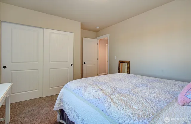 a bathroom with a granite countertop toilet a sink a mirror and a window
