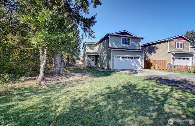 a front view of a house with a yard and trees