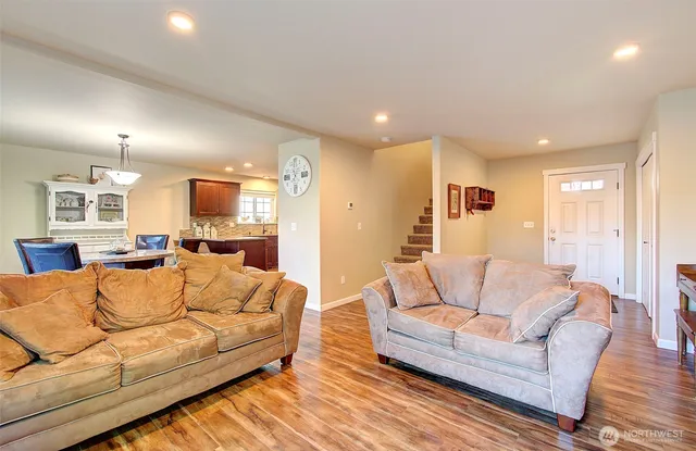 a living room with furniture white walls and wooden floor