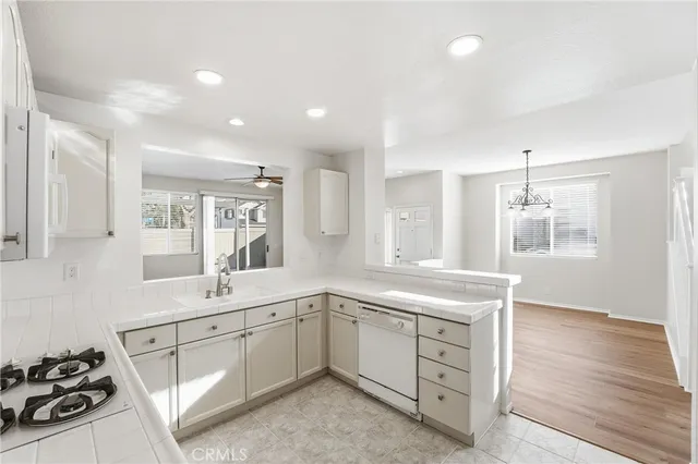 a kitchen with granite countertop a sink stove and cabinets