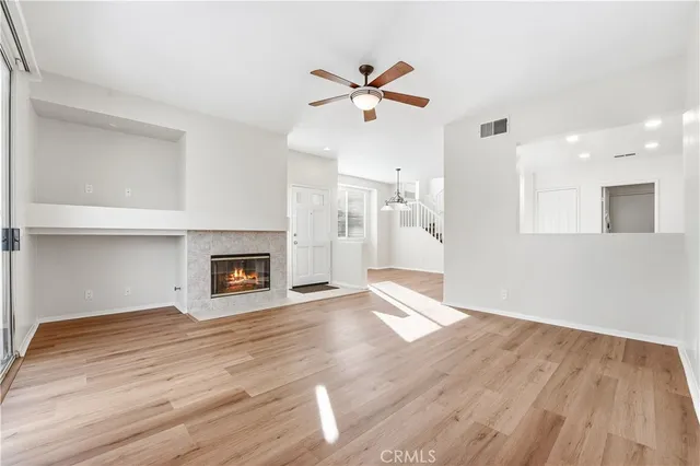 a view of empty room with wooden floor and fireplace
