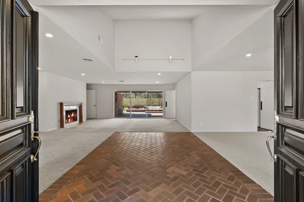 a view of an empty room with a window and fireplace
