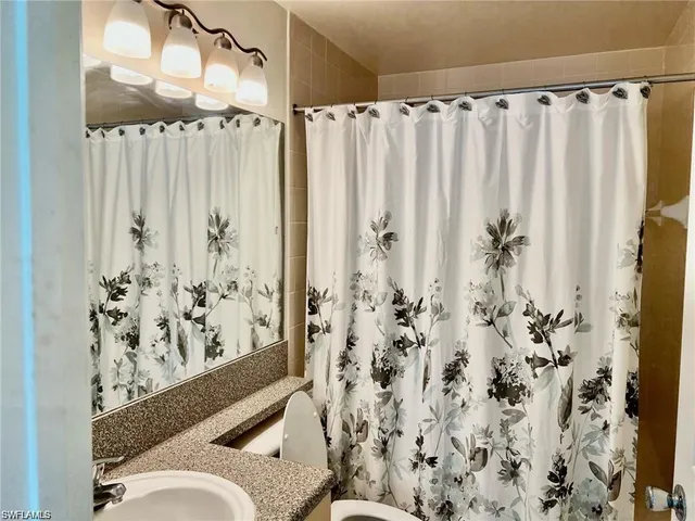 a bathroom with a toilet and shower curtain