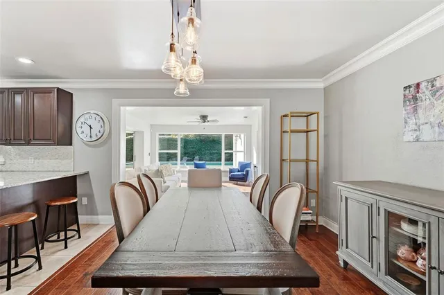a view of a dining room with furniture a chandelier and wooden floor