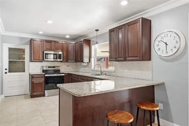 a kitchen with stainless steel appliances granite countertop a sink dishwasher stove and refrigerator