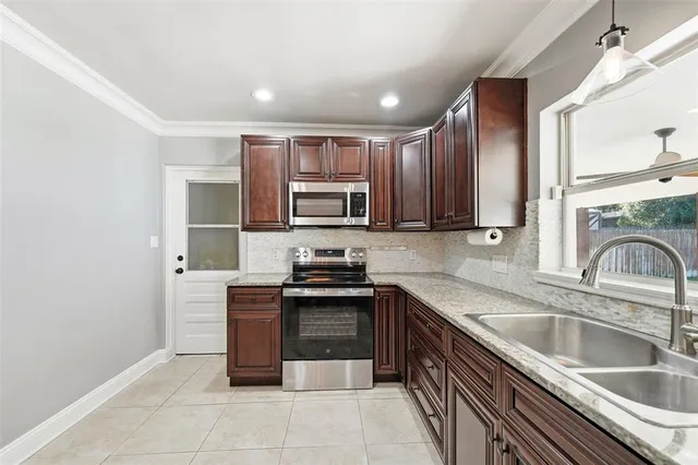 a kitchen with stainless steel appliances granite countertop a sink stove and refrigerator