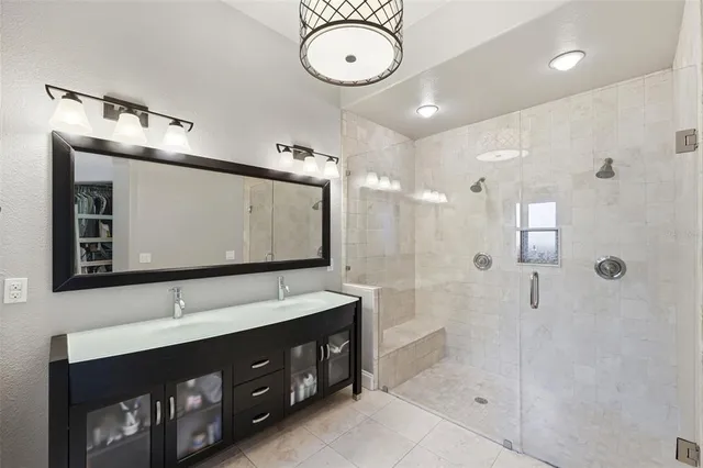 a bathroom with a double vanity sink mirror and shower