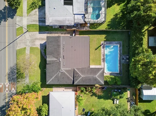 an aerial view of a house with a yard swimming pool a yard and outdoor seating