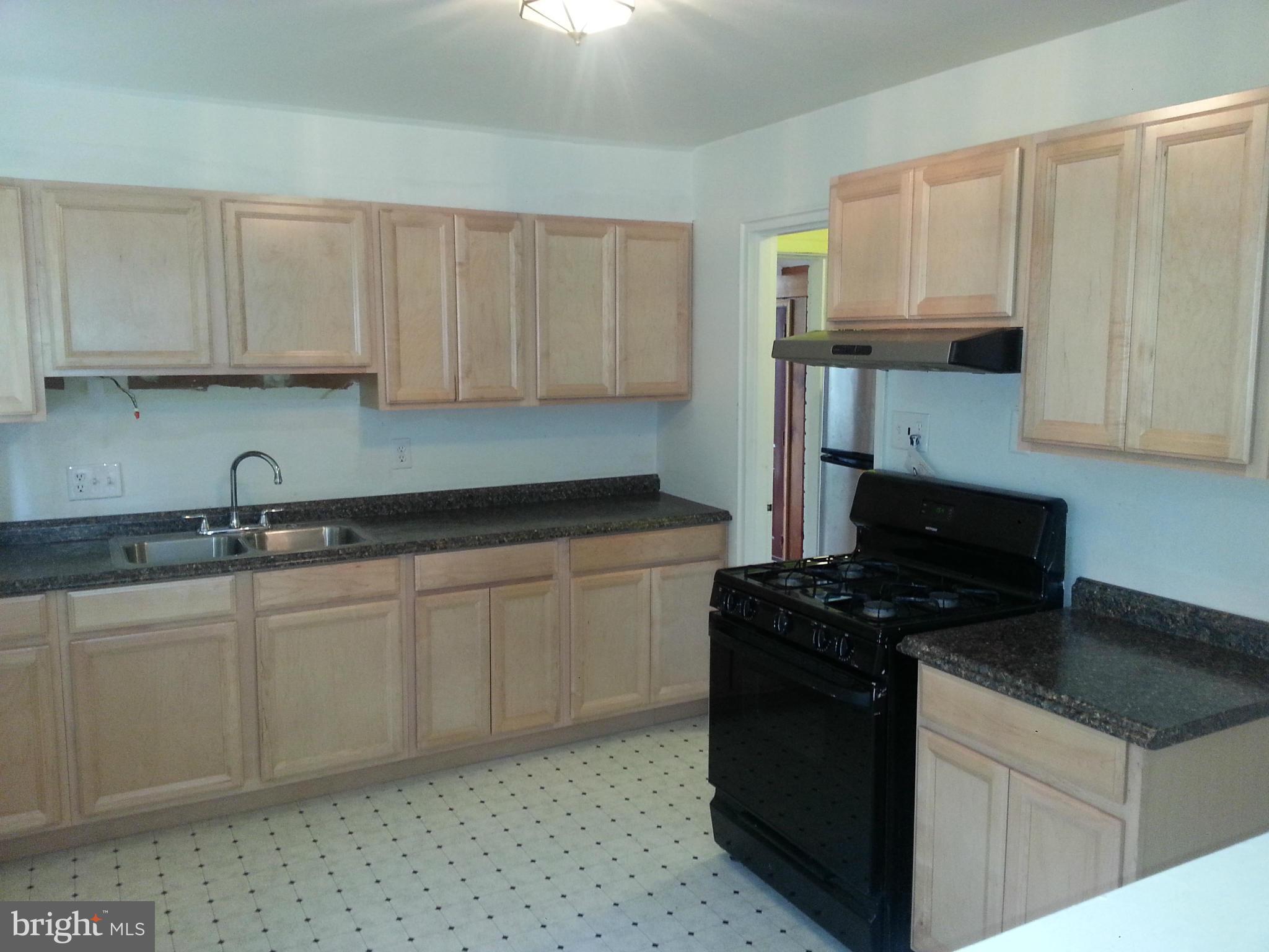 12701 Gould Road Silver Spring, MD 20906 - Photo 12 of 30 a kitchen with granite countertop a sink a stove and cabinets
