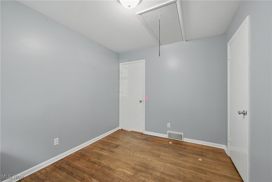 7835 Elyria Road Medina, OH 44256 - Photo 16 of 46 Spare room with attic access, wood finished floors, and baseboards