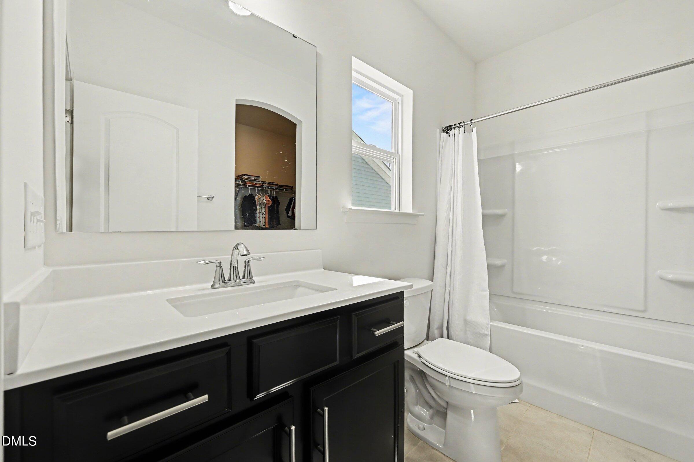 7015 Grainfield Road Mebane, NC 27302 - Photo 33 of 42 a bathroom with a sink a toilet a mirror and shower