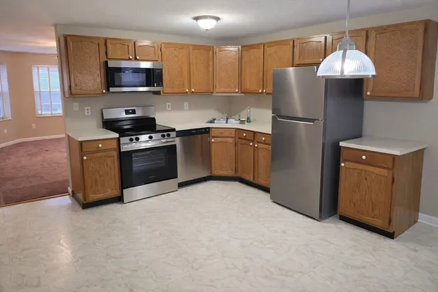 a kitchen with stainless steel appliances granite countertop a refrigerator stove a sink and a microwave