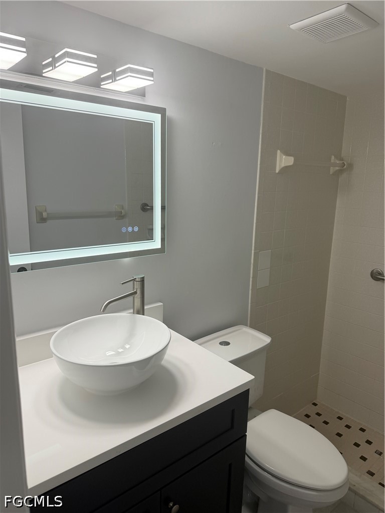 1100 Pondella Road, Unit 703 Cape Coral, FL 33909 - Photo 12 of 16 a bathroom with a sink a mirror and a toilet