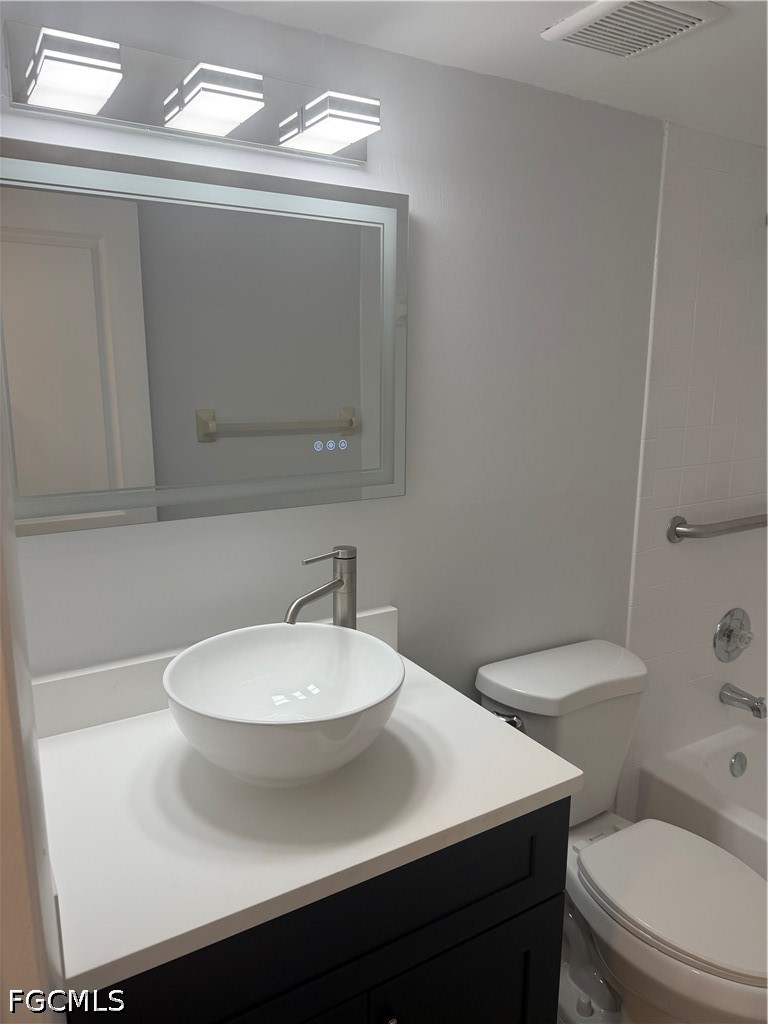 1100 Pondella Road, Unit 703 Cape Coral, FL 33909 - Photo 15 of 16 a bathroom with a sink a toilet and mirror