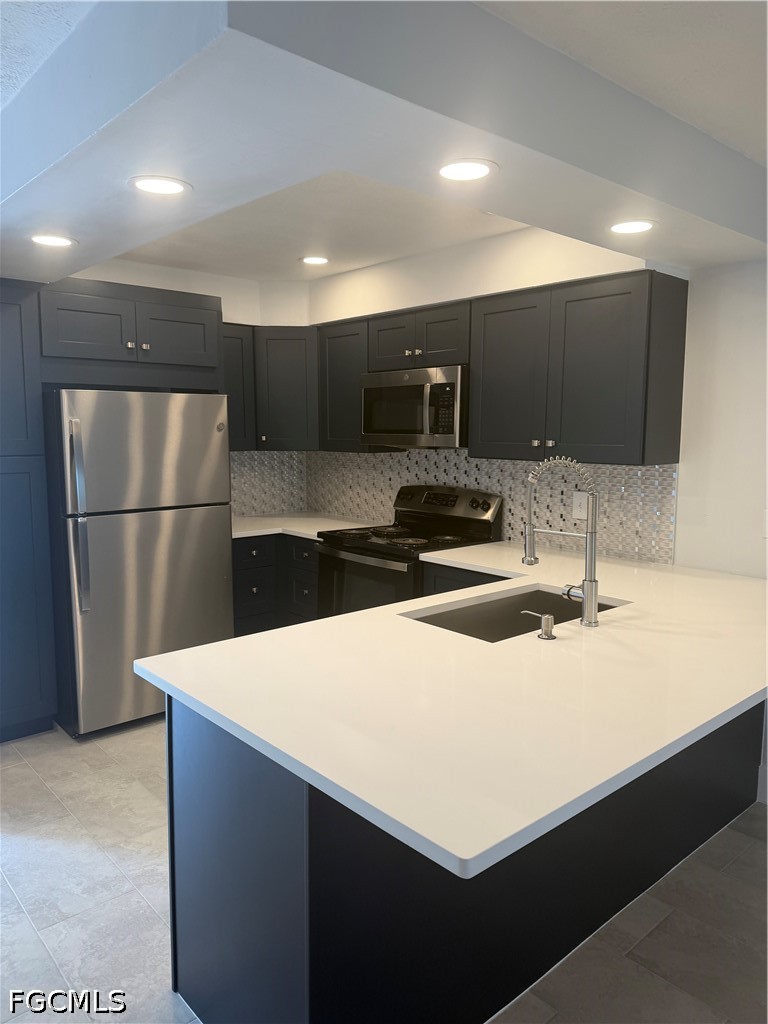 1100 Pondella Road, Unit 703 Cape Coral, FL 33909 - Photo 8 of 16 a kitchen with stainless steel appliances a refrigerator sink and microwave