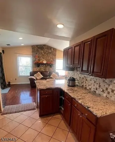 a kitchen with kitchen island granite countertop a refrigerator stove and oven