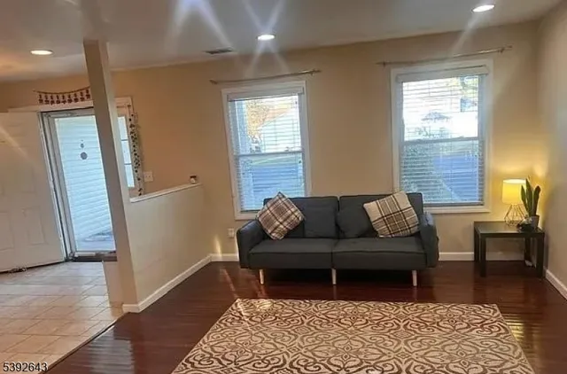 a living room with furniture and wooden floor