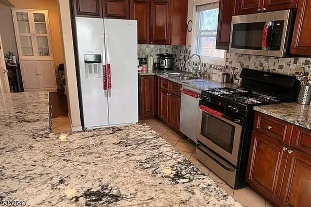 a kitchen with granite countertop a stove sink and cabinets