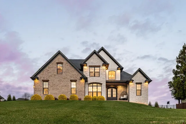 a view of an empty room with wooden floor and chandelier