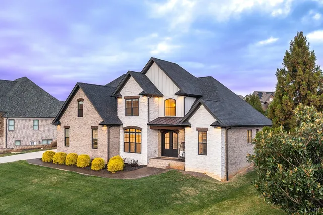 an aerial view of a house with a garden and lake view