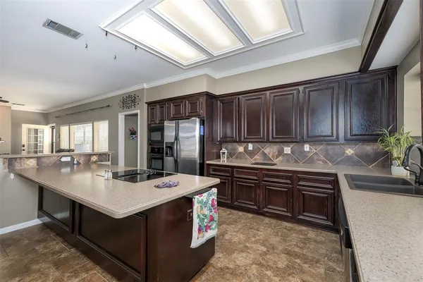 a kitchen with kitchen island granite countertop a sink stove and cabinets