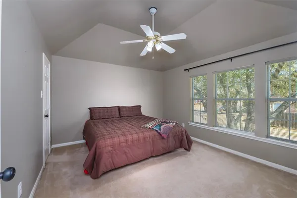 a bedroom with a large bed and a chandelier
