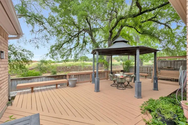 a view of a patio with table and chairs potted plants with wooden floor and fence