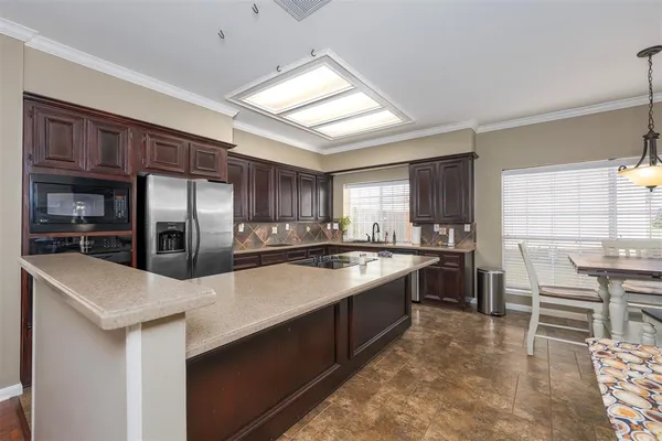 a large kitchen with kitchen island a sink stainless steel appliances and cabinets