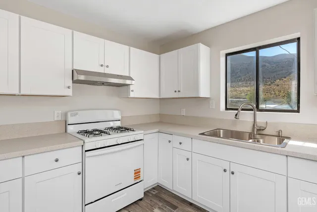a kitchen with white cabinets and white appliances