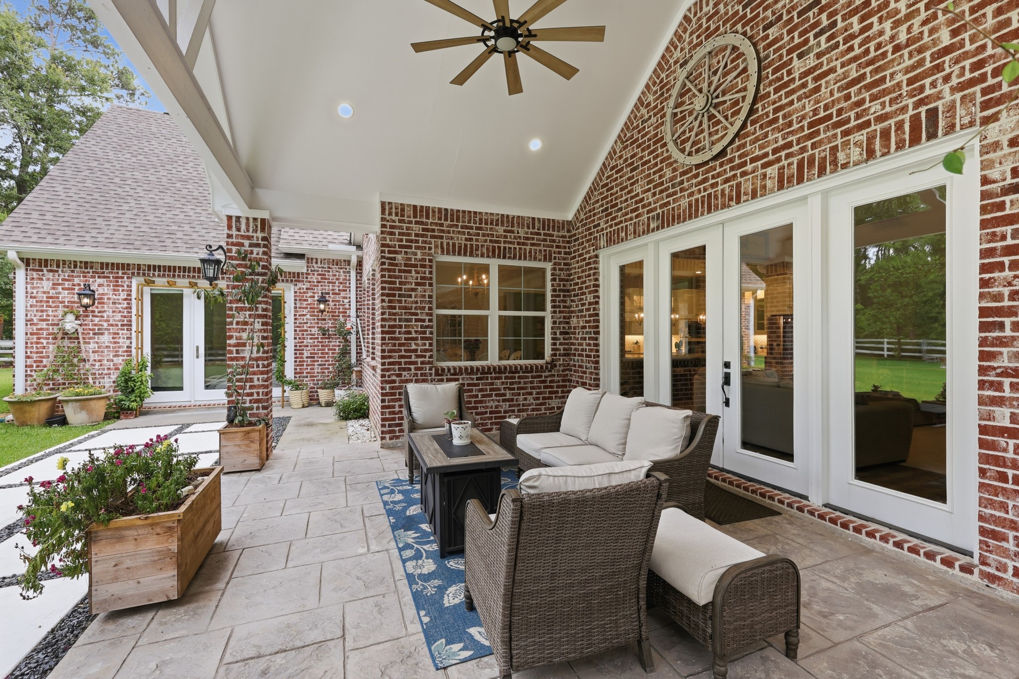 7106 Hampton Court Spring, TX 77389 - Photo 22 of 31 Covered backyard patio featuring comfortable seating, a ceiling fan, and decorative details. It's a cozy outdoor space perfect for relaxation and entertaining, with views of a landscaped yard.