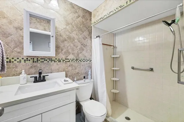 a bathroom with a sink toilet and shower