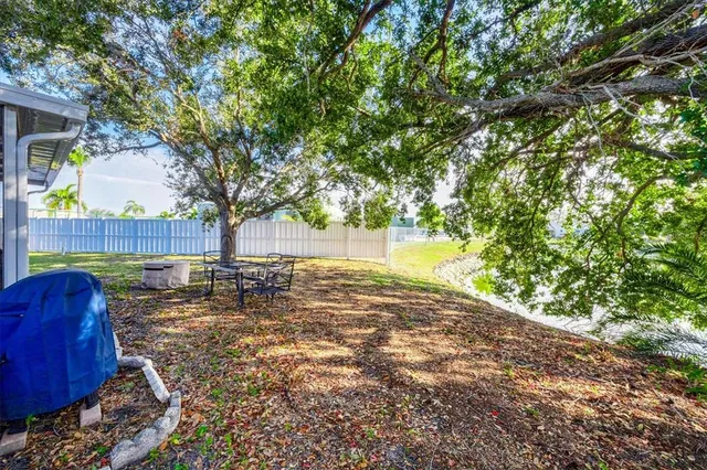 a view of backyard with tree and wooden fence