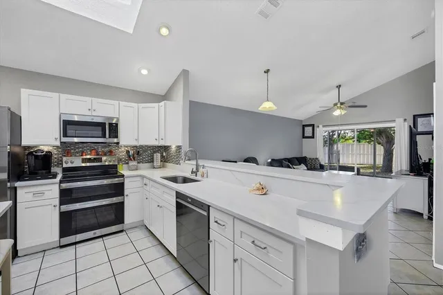 a kitchen with a sink a stove top oven and cabinets
