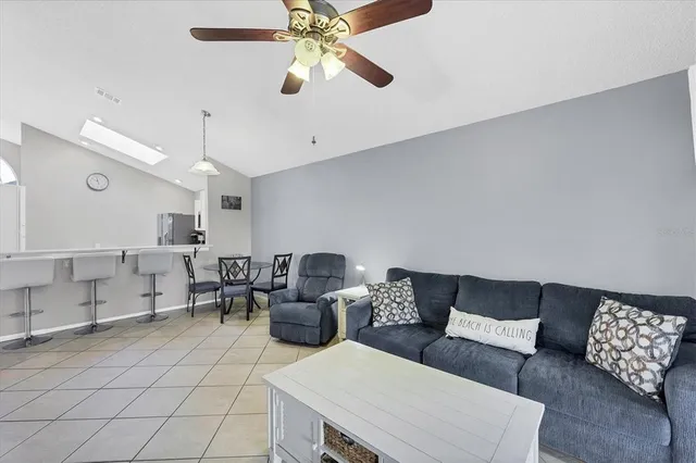 a living room with furniture and a ceiling fan