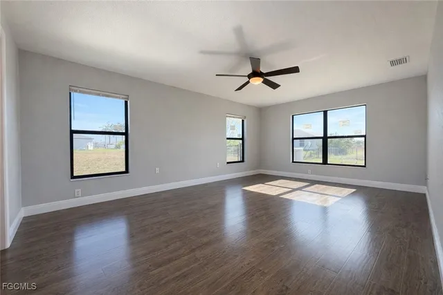 a view of an empty room with wooden floor