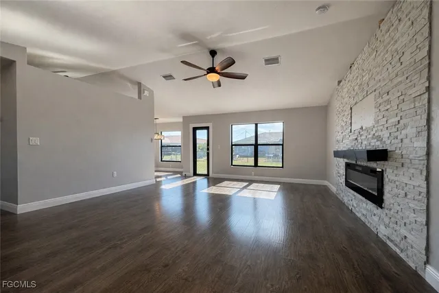 an empty room with windows fireplace and windows
