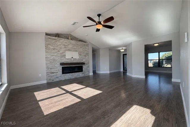 a living room with wooden floor and a fireplace