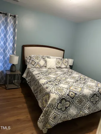 a large bed sitting in a bedroom next to a lamp and a lamp