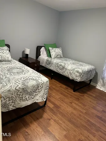 a bedroom with a bed and wooden floor