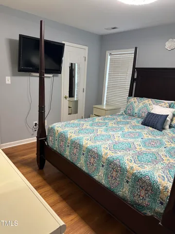 a bedroom with a bed and a flat screen tv