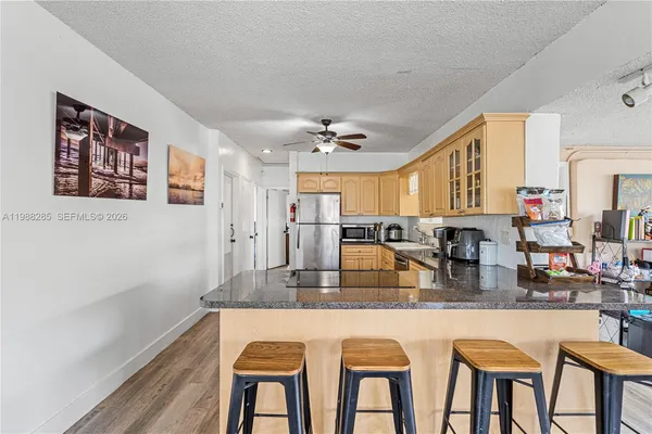 a kitchen with granite countertop white cabinets and chairs