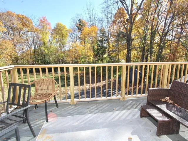 a view of a chair and table in the back yard of the house