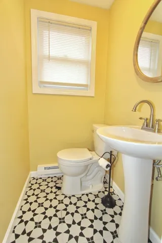 a bathroom with a sink a toilet and a mirror