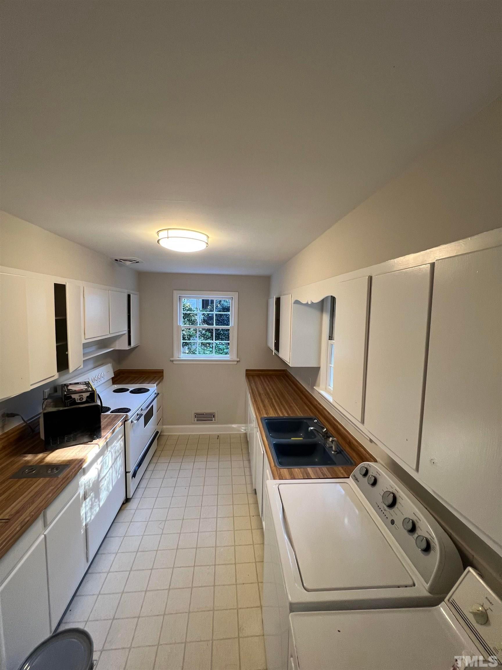 913 Brookwood Drive Raleigh, NC 27607 - Photo 16 of 26 a kitchen with a stove and a refrigerator