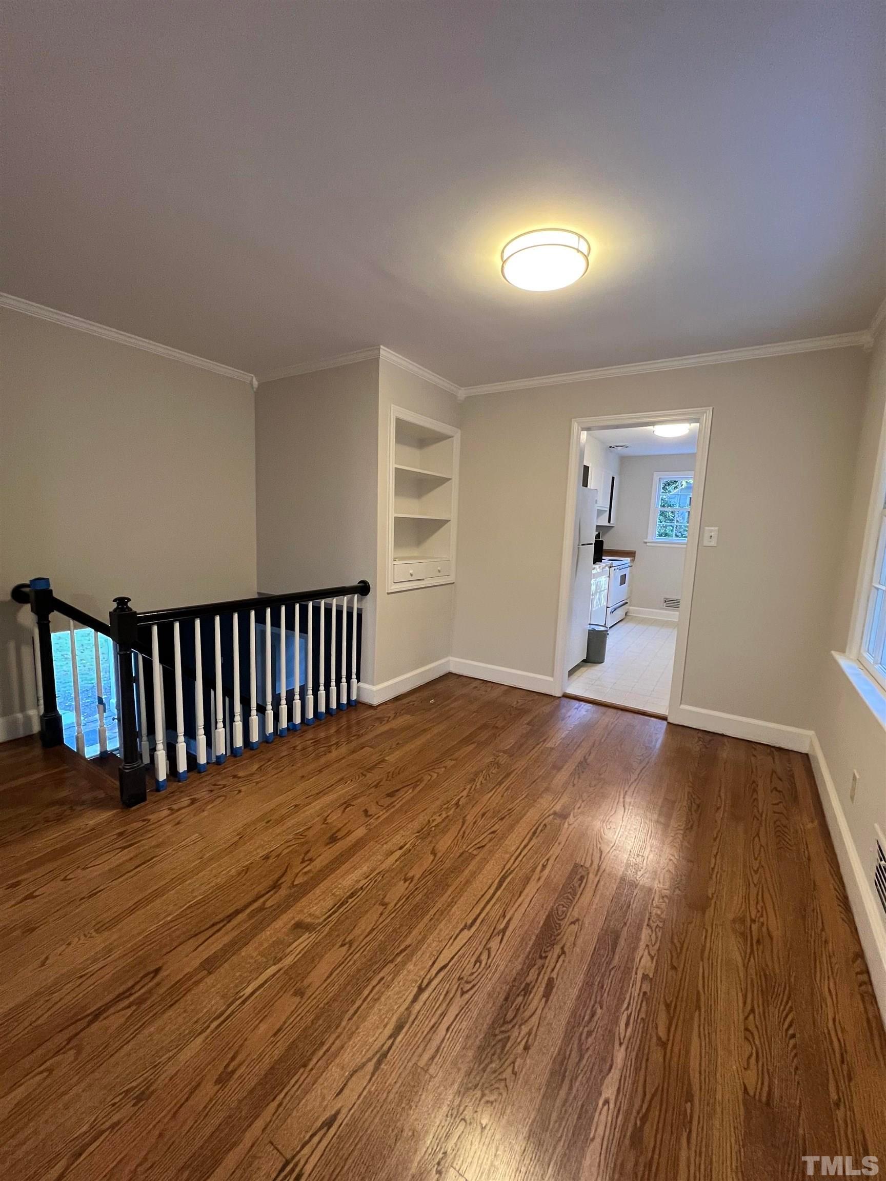 913 Brookwood Drive Raleigh, NC 27607 - Photo 21 of 26 an empty room with wooden floor and windows