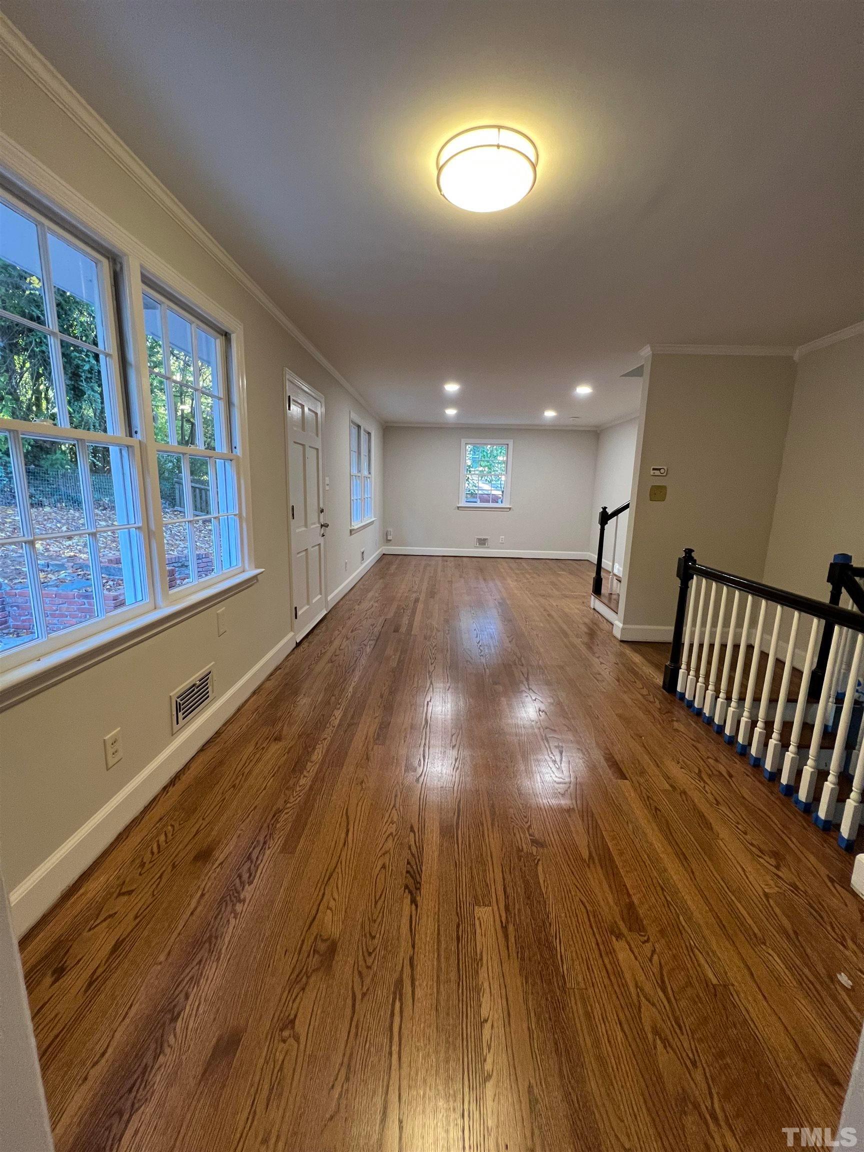 913 Brookwood Drive Raleigh, NC 27607 - Photo 23 of 26 a view of an empty room with wooden floor and windows
